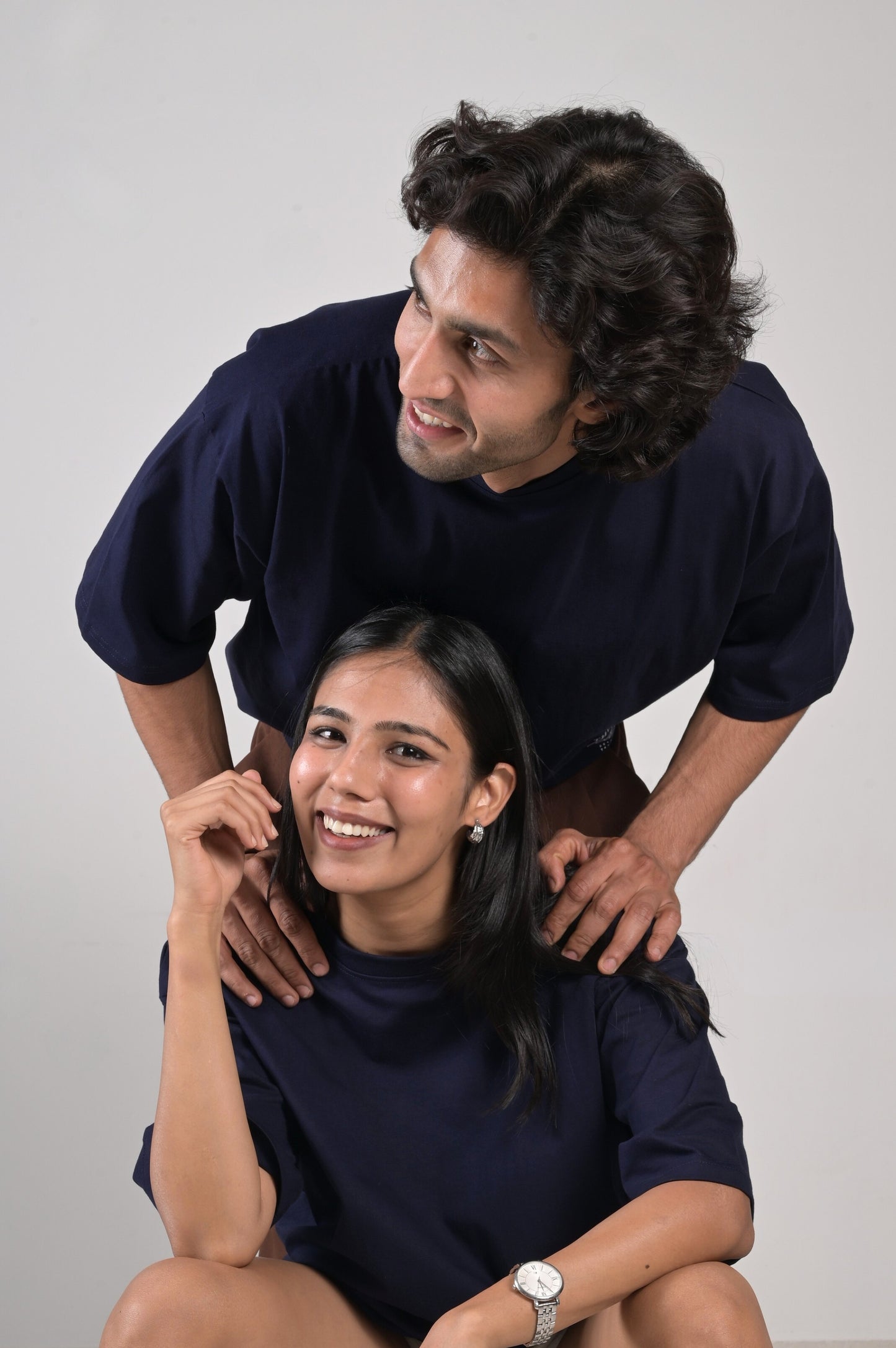 Two people posing together against a plain background