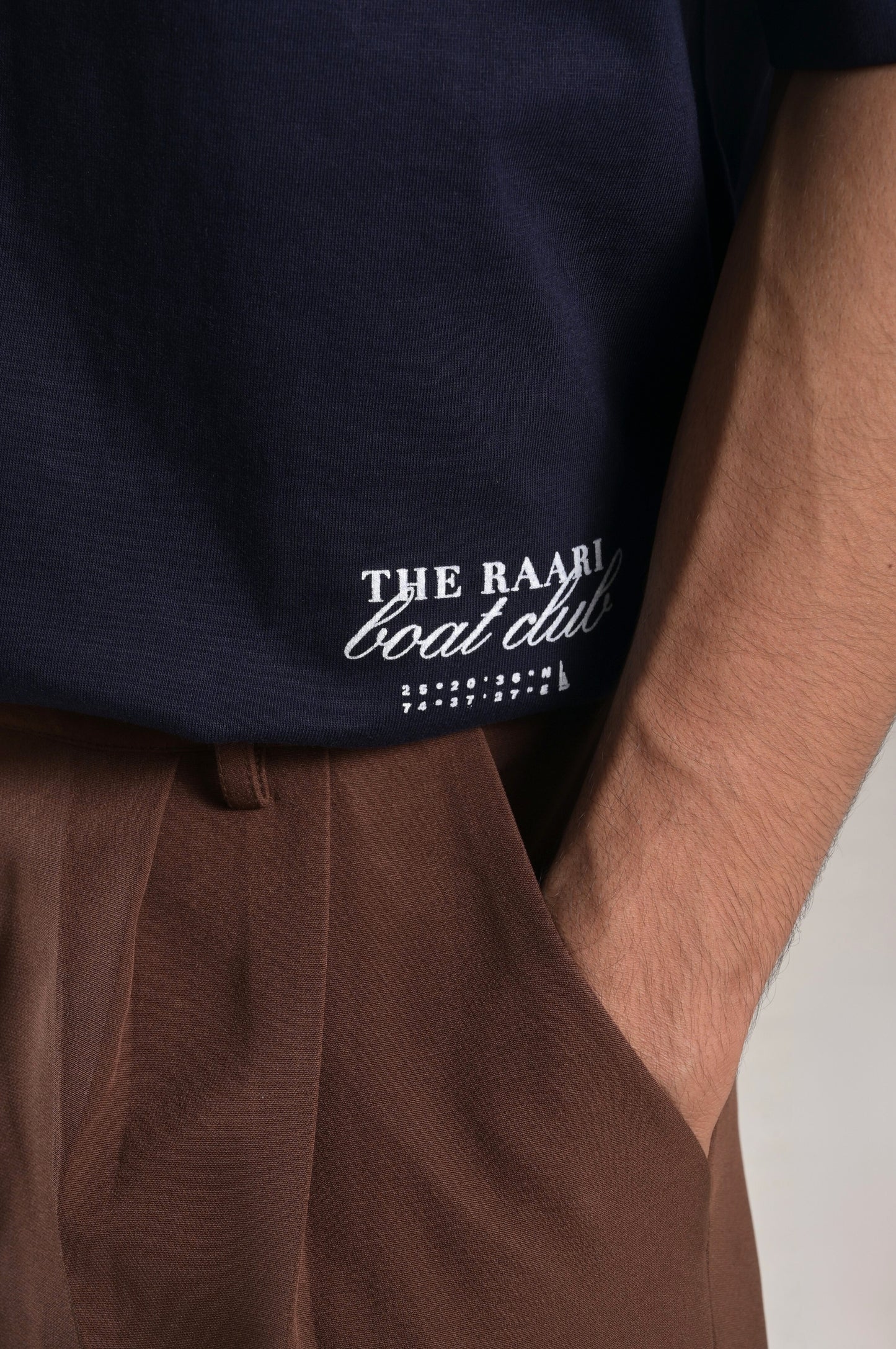 Navy blue t-shirt with 'The Raari Boat Club' logo worn by a person.